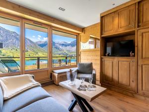 a living room with a tv and a couch and a table at Apartment Les Cimes - Le Lac by Interhome in Tignes +25 photos