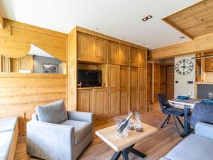 a living room with wooden walls and a clock on the wall at Apartment Les Cimes - Le Lac by Interhome in Tignes +25 photos