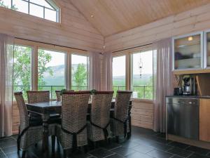 ein Esszimmer mit Tisch und Stühlen und Fenstern in der Unterkunft Holiday Home Haltinsaana by Interhome in Kilpisjärvi
