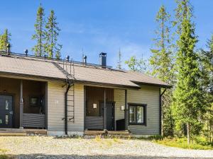 une petite maison avec une véranda et des arbres dans l'établissement Holiday Home Aihki b by Interhome, à Syöte