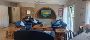 a living room with blue chairs and a table at Cycasia Lodge in Umzumbe