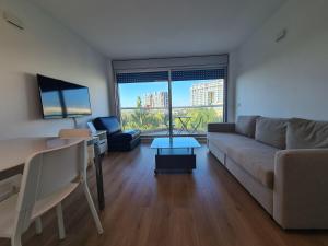 een woonkamer met een bank en een tafel bij Herzliya Marina - By Beach Apartments TLV in Herzliyya B
