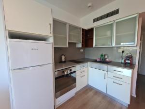 eine Küche mit weißen Schränken und einem weißen Kühlschrank in der Unterkunft Herzliya Marina - By Beach Apartments TLV in Herzliya B