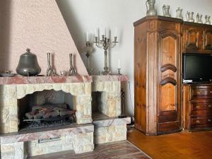 a living room with a stone fireplace and a tv at Apartment Fifinhaus by Interhome in Fiesch