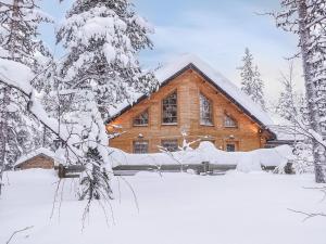 eine Blockhütte im Schnee mit Bäumen in der Unterkunft Holiday Home Sarah dreamhome in lapland by Interhome in Kittilä