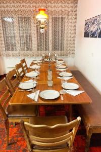 a long wooden table with chairs and plates on it at Apartment Fifinhaus by Interhome in Fiesch