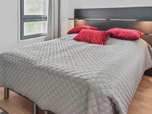 um quarto com uma cama com almofadas vermelhas em Holiday Home Ylälänsi 3 as 11 by Interhome em Ylläsjärvi