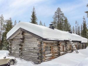 a log cabin in the snow with a snow covered roof at Holiday Home Aihkelo by Interhome in Luosto