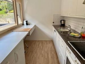 een keuken met witte kasten, een wastafel en een raam bij Apartment Alte Gasse 9 by Interhome in Engelberg