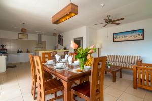 comedor y cocina con mesa y sillas en Tropical Hideaway, en Beau Vallon