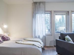 1 dormitorio con 1 cama, 1 silla y 1 ventana en Holiday Home Levin stara a08 by Interhome, en Sirkka