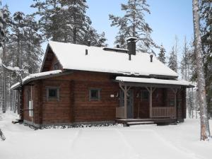 Cabaña de madera con nieve en el techo en Holiday Home Kiehtäjän virta by Interhome, en Käylä
