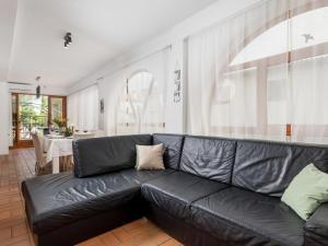 Holiday Home Noveanni by Interhome في كورنيك: أريكة جلدية سوداء في غرفة معيشة مع طاولة