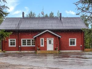 a red house with a white door in a parking lot at Holiday Home Porukka 1 by Interhome in Sirkka