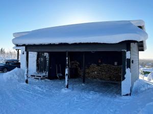 una casa cubierta de nieve con techo en Holiday Home Villa viima by Interhome, en Saariselkä