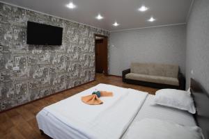 um quarto de hotel com uma cama com uma toalha em Majestic em Petropavl