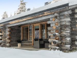 a log cabin with a porch in the snow at Holiday Home Sallan savu a by Interhome in Salla