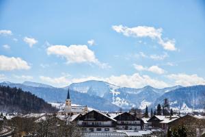 a town with a church and mountains in the background at Lindner Hotel Oberstaufen Parkhotel, part of JdV by Hyatt in Oberstaufen