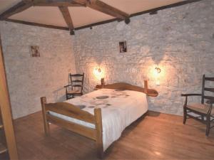 een slaapkamer met een bed in een kamer met stenen muren bij Holiday Home Le Pigeonnier Jacques by Interhome in Dondas
