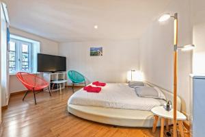 a bedroom with a bed and a desk and chairs at Villa Sur le Port in Roscoff