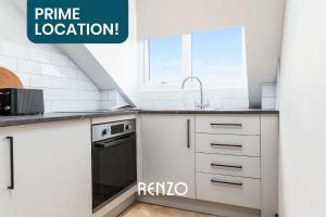 a white kitchen with a sink and a stove at Stylish Studio Apartment in Derby by Renzo, Free Parking, Well Equipped Kitchen! in Derby