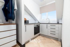 a kitchen with white cabinets and a sink at Stunning Studio Apartment in Derby by Renzo, Free Parking, Well Equipped Kitchen! in Derby