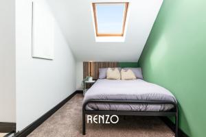 德比的住宿－Stunning Studio Apartment in Derby by Renzo, Free Parking, Well Equipped Kitchen!，一张位于带绿色和白色墙壁的房间的床铺