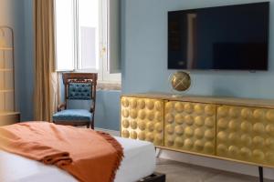 a bedroom with a dresser with a tv on top at Palazzo Murat Luxury Rooms in Arienzo San Felice