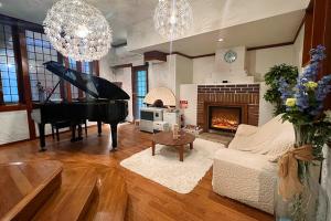 山中湖的住宿－Windy hill 森の宿，客厅配有钢琴和壁炉