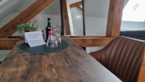 a table with a bottle of wine and glasses on it at Exclusives LOFT mit Netflix & Disney, privat Parkplatz, Dominos Pizza, Bahnhof & Stadthalle 500m in Falkensee