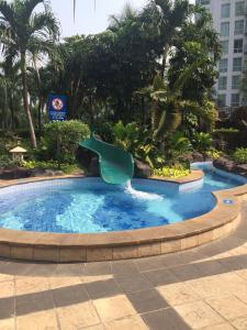 a slide in a swimming pool in a resort at The Residences at Puri Casablanca in Jakarta