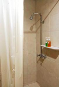 y baño con ducha y cortina de ducha. en Sun Hotel en Phetchaburi