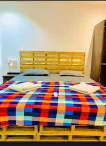 a bed with a colorful blanket on top of it at Palolem Cottages in Palolem