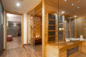 uma cabina de duche ao nível do chão com uma parede de vidro em Onyx Luxury em Sárvár