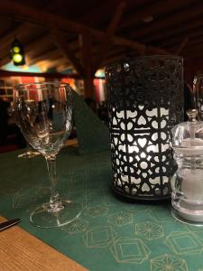 a table with a wine glass and a lantern on it at Hunderfossen Snow Hotel in Hafjell