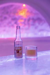 une bouteille de soda assise à côté d'un verre dans l'établissement Hunderfossen Snow Hotel, à Hafjell