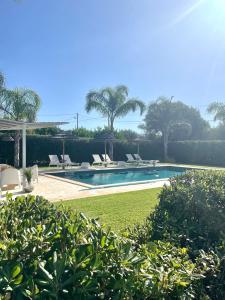 a swimming pool with lounge chairs and a resort at B&B Sun Of Sicily in Noto