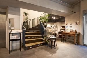 a room with a staircase and a table and a desk at Hotel Morning Box Osaka Shinsaibashi in Osaka