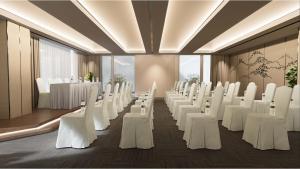 西哈努克的住宿－SIHA Hotel & Casino，一间设有一排白色椅子和桌子的房间