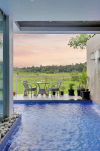 einen Pool mit Tischen und Stühlen neben einem Haus in der Unterkunft Elivaas Risaia Luxe 4BHK Villa with Pvt Pool, Nerul in Nerul