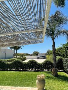 a vase sitting in the grass under a white umbrella at B&B Sun Of Sicily in Noto