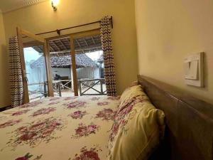a bedroom with a bed and a view of a porch at Bhome Zanzibar in Kiwengwa