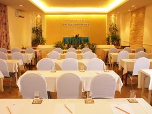 una sala de conferencias con mesas y sillas blancas en Sun Hotel, en Phetchaburi