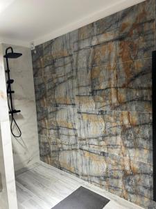eine Steinmauer im Bad mit Dusche in der Unterkunft Apartment Hamburg Perle in Hamburg
