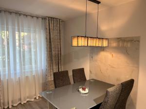 comedor con mesa, sillas y lámpara de araña en Apartment Hamburg Perle en Hamburgo