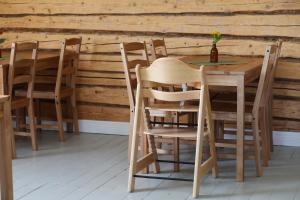 una mesa de madera y sillas frente a una pared de madera en Övermark Bed & Breakfast, 