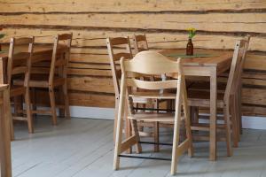 a wooden table and chairs in front of a wooden wall at Övermark Bed & Breakfast in Ylimarkku