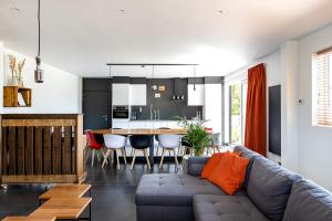 a living room and kitchen with a couch and a table at Vakantieverblijf De Backstage in Heuvelland