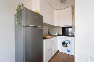 a kitchen with a refrigerator and a washer and dryer at Le Libération - Paris Disney - 2 min gare in Bussy-Saint-Georges