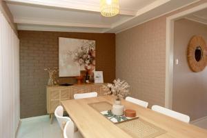 a dining room with a wooden table and white chairs at Sunset Balcony Bass Coast Beach House in Grantville